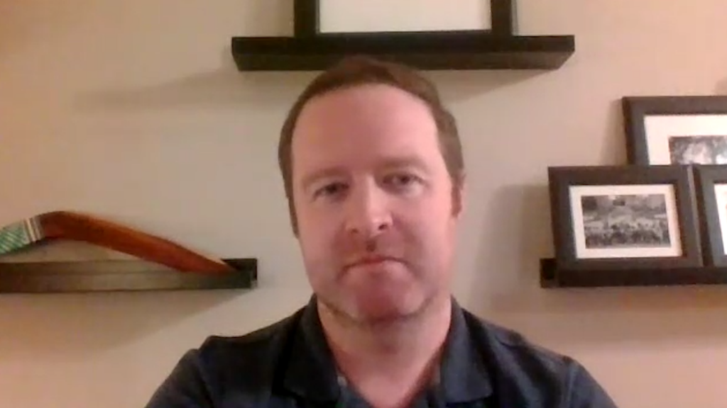 David Krulicki, our case study patient, is wearing a navy polo shirt and a has a slight grin as he joins the Zoom meeting. Family photos are behind him on the wall of his home office.