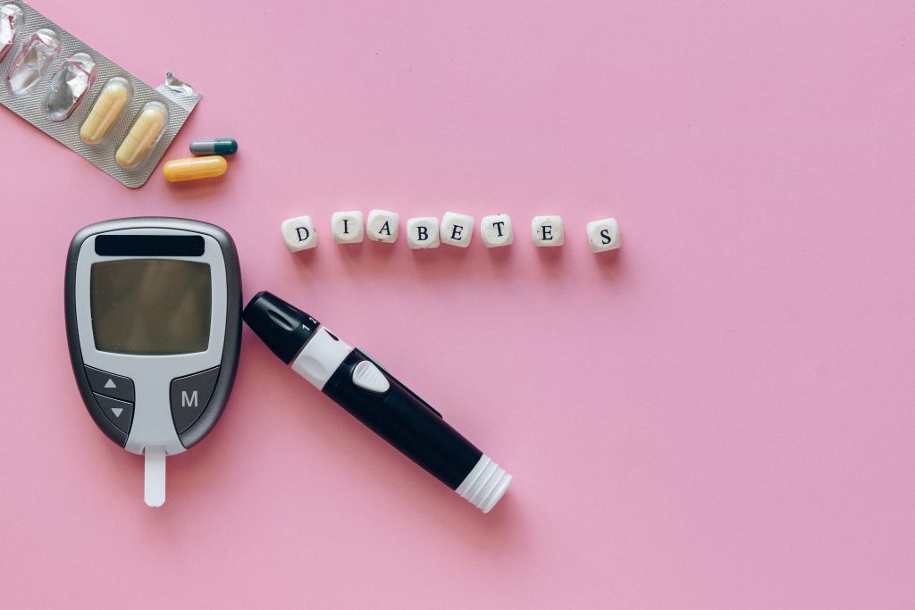 A glucometer, lancet device, and various medications are displayed next to beads that spell "Diabetes"
