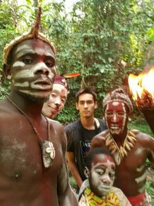 This is an image with Ewan Cassidy, the author with Bwiti men in a treed area in Africa.