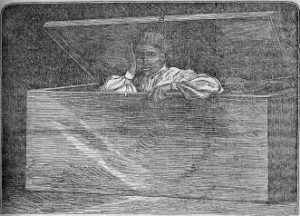Lear Green sitting up inside a wooden chest