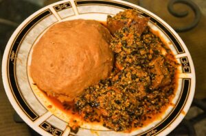 Egusi soup with wheat fufu. Click the image to learn more at blessinglicious.ca on a new tab.