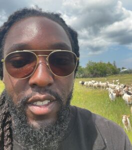 This is an image of Kishon Warmington, who stands proudly on his family farmland, embodying the legacy of agriculture and a strong commitment to regenerative food systems.