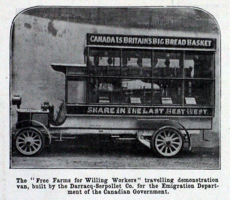 A black and white photo of a double-decker demonstration van used by the Canadian Department of Immigration in the UK. The side of the van reads “Canada is Britain’s Big Bread Basket” and “Share in the Last Best West.” It was built to promote free farmland to British workers.