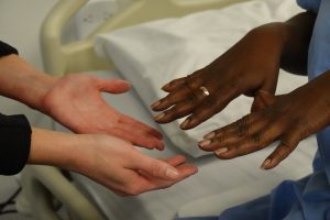 Nurse inspecting client's nail condition.